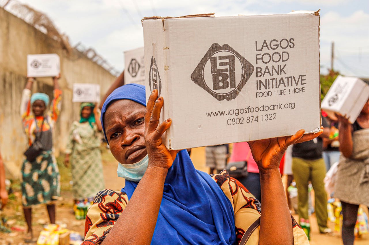 Community members engage in food distribution at Lagos Food Bank initiative event.